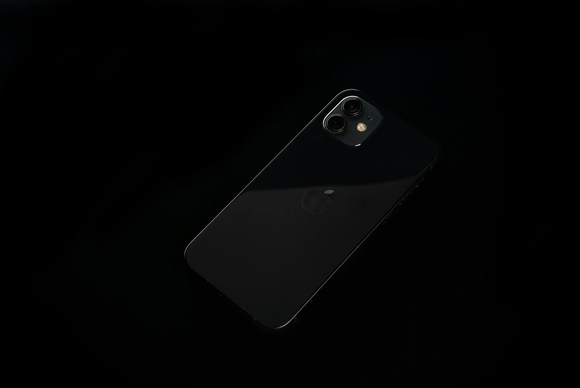 A minimalist close-up of a black smartphone on a dark background, showcasing modern technology.