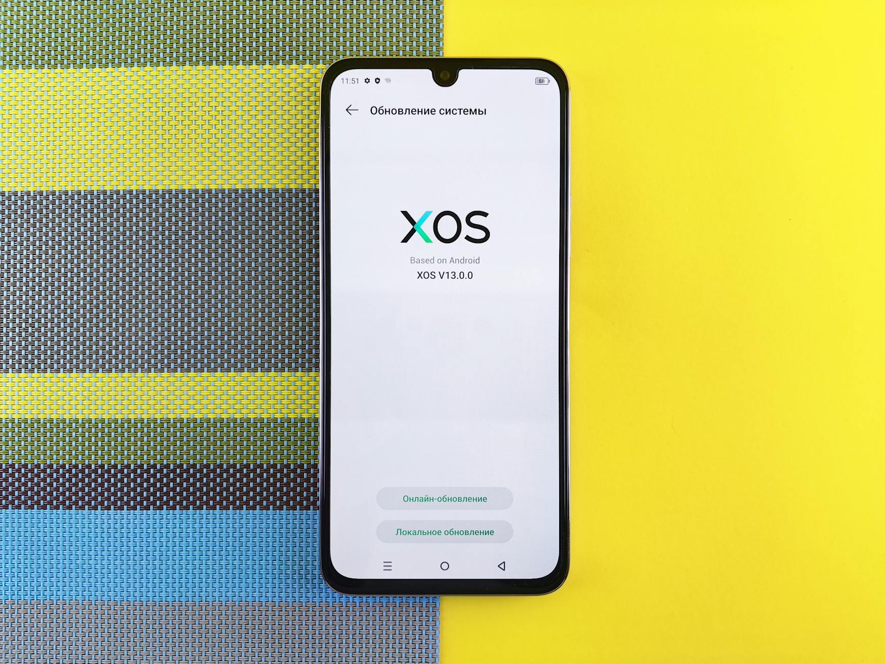 Smartphone on colorful background showing XOS version update, based on Android.