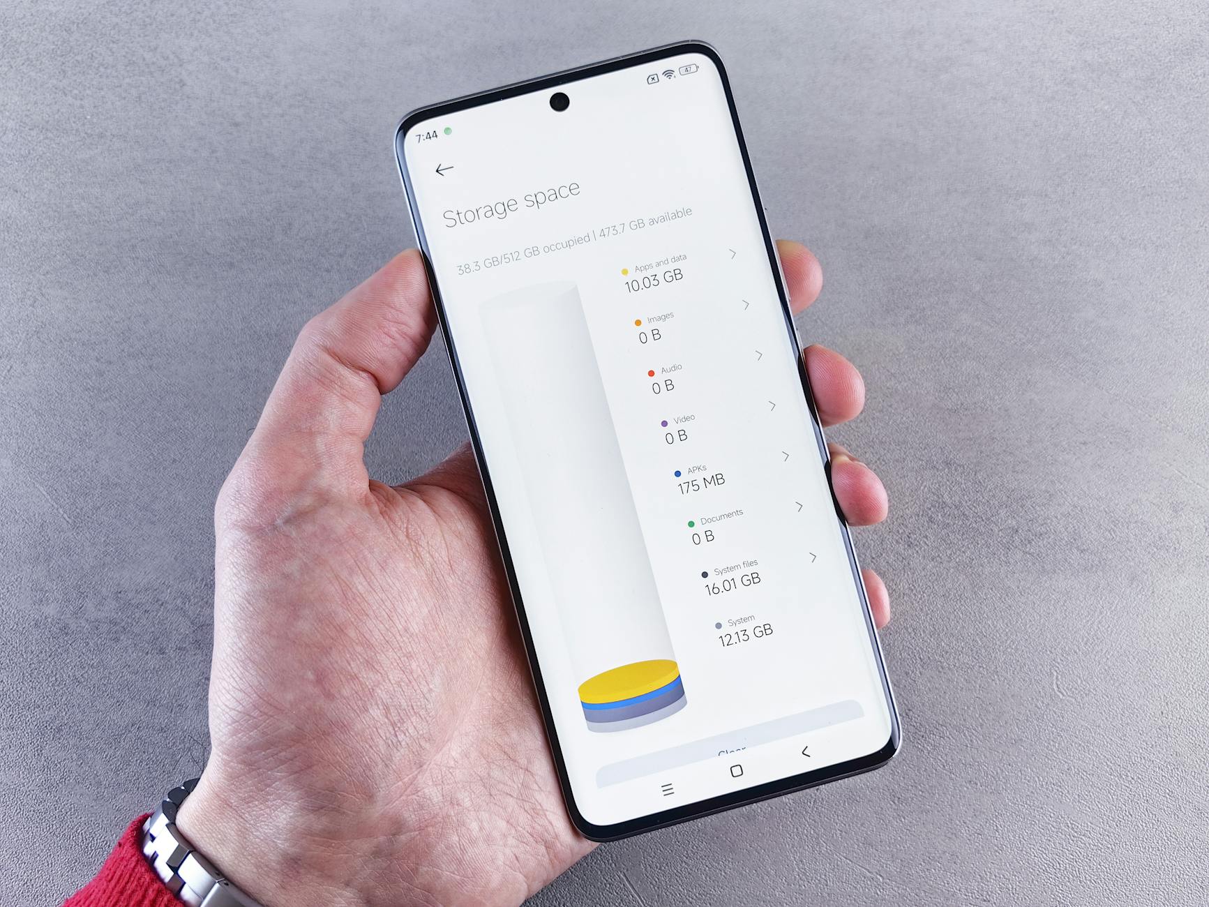 Hand holding smartphone displaying storage space usage with a clean interface.